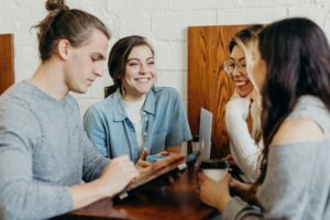 A group of students in a cafe laughing and talking