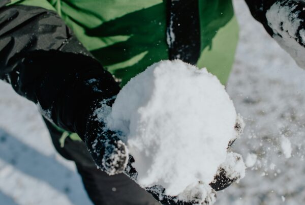 A person wearing gloves holding a snowball (budgeting for the holidays)