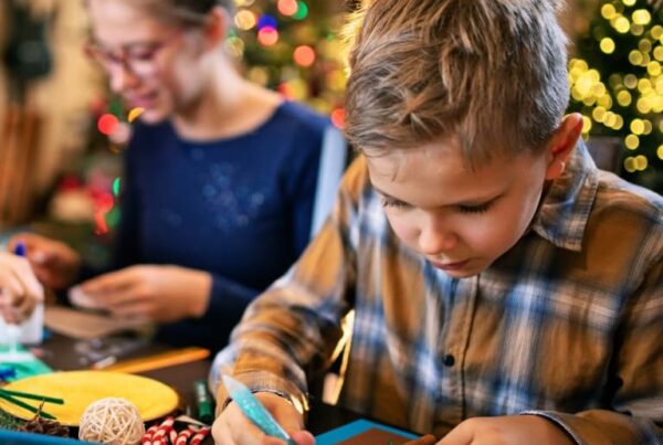 Young child crafting with their mother at home in the interest of budget friendly gift ideas