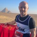 MyBnk runner Darren Collins smiles in front of the pyramids in Gize before running a half marathon in Cairo